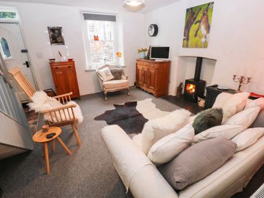 A living room with a sofa and a television at 11 Church Street in Narberth