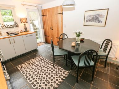 A kitchen with a dining table and cabinet at 11 Church Street in Narberth