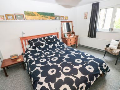 A bedroom with a bed, bedside table and mirror at 11 Church Street Narberth