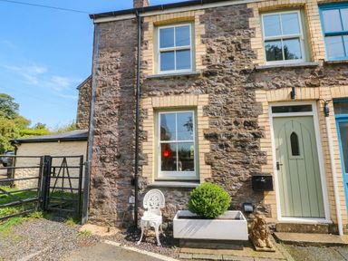 An exterior view of a house with a stone wall and a planter at 11 Church Street, Narberth