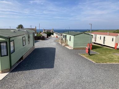 A view of caravans and pathway near the sea at Beautifully Presented 2 Bedroom Static Caravan in Monreith near Whithorn
