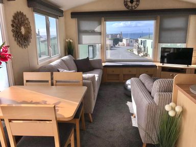 A living room with a sofa and dining table at Beautifully Presented 2 Bedroom Static Caravan in Monreith near Whithorn