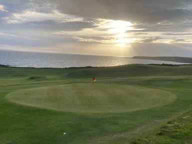 A golf course with a putting green and flag by the sea at Beautifully Presented 2 Bedroom Static Caravan in Monreith near Whithorn