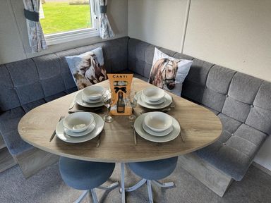 A dining area with a table set for four at West Lawn 47 Haggerston Castle Paddock Views Haggerston