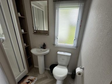 A bathroom with a shower, toilet, and sink at West Lawn 47 Haggerston Castle Paddock Views Haggerston
