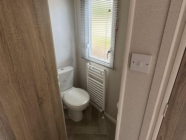A bathroom with a toilet and radiator at West Lawn 47 Haggerston Castle Paddock Views Haggerston