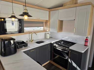 A kitchen with appliances and cabinetry at 3 Bed-Sleeps 8-Free Parking-5 Min to Beach in Embo near Dornoch