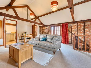 A living room with a sofa and coffee table at Barn Conversion Sleeps 2 with Parking in Diss