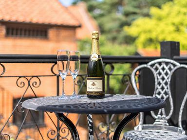 Outdoor area with a table, champagne bottle and glasses at Barn Conversion Sleeps 2 with Parking, Diss