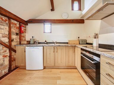 A kitchen with cabinets, sink, and appliances at Barn Conversion Sleeps 2 with Parking in Diss