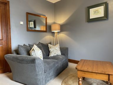 A living room with a sofa, lamp, and coffee table at Milecastle Inn on Hadrian's Wall near Haltwhistle