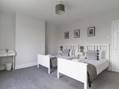 A bedroom with two beds and bedside tables at East House-Sleeps 5-Pet friendly-Garden-Parking in Stakeford