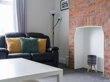 A living room with a sofa and cushions at East House-Sleeps 5-Pet friendly-Garden-Parking in Stakeford