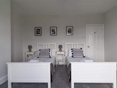 A bedroom with two beds and bedside tables at East House-Sleeps 5-Pet friendly-Garden-Parking in Stakeford