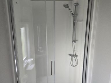 A shower with a showerhead and a soap dish at 3 Bedroom Cabin Sleeps 6 - Shared Pool & Shared Hot Tub, Flamingo Land Resort near Malton