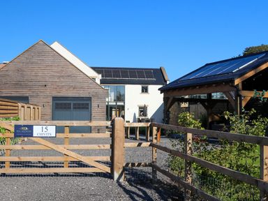 A house with solar panels and a gated entrance at Northumberland Luxury Stays - The Chivits West Chevington near Amble