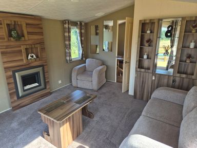 A living room with a fireplace and furniture at Cabin - Sleeps 6 - Outdoor Pool and Parking in Cenarth