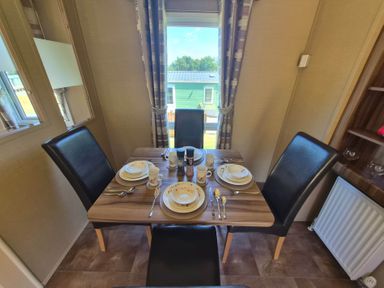 A dining room with a table set for meals at Cabin - Sleeps 6 - Outdoor Pool and Parking, Cenarth