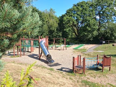 A playground with a slide and swings at a park in Cenarth
