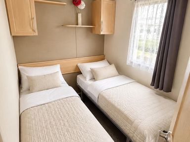 A bedroom with two single beds and a shelf at Seaside Tranquility Retreat in Clacton