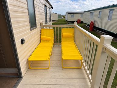 An outdoor deck with yellow lounge chairs at Seaside Tranquility Retreat in Clacton