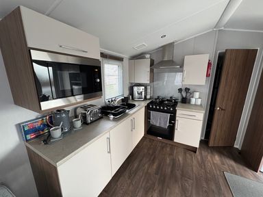 A kitchen with appliances and storage at Wl34 Caravan Haggerston Castle Private Decking Haggerston