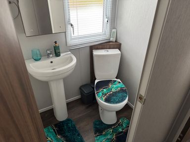 A bathroom with a wash basin and toilet at Wl34 Caravan Haggerston Castle Private Decking in Haggerston