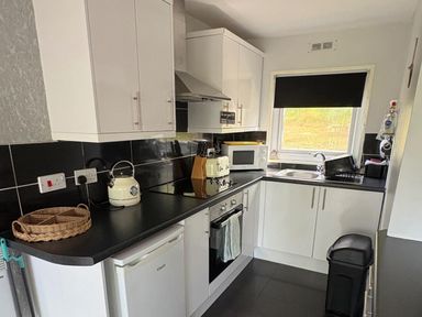 A kitchen with cabinets and appliances at Pet Friendly 2-Bed Lodge, Sleeps 5, Pool & Parking, Caernarfon