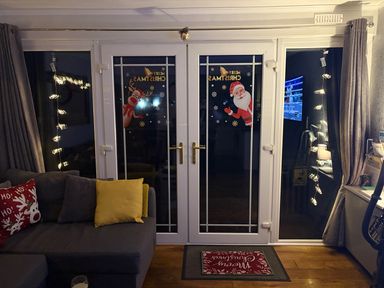 A snug with sliding glass doors decorated for Christmas at Pet Friendly 2-Bed Lodge, Sleeps 5, Pool & Parking, Caernarfon