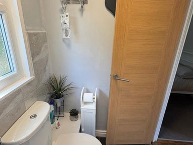 A bathroom with a toilet and window at Pet Friendly 2-Bed Lodge, Sleeps 5, Pool & Parking in Caernarfon