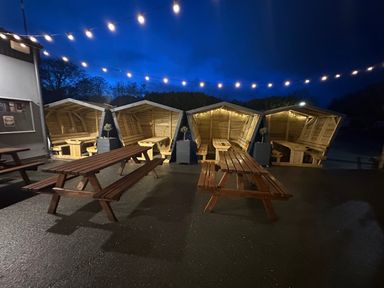 An outdoor area with wooden huts and picnic tables at Pet Friendly 2-Bed Lodge, Sleeps 5, Pool & Parking, Caernarfon
