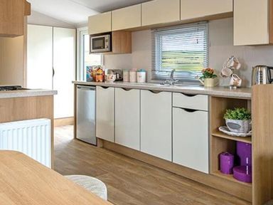 A kitchen with cabinets and appliances at Seafront Caravan - Golden Sands - 6 Berth by Your Away Stays Kinmel Bay