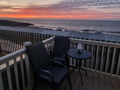 A patio with chairs and a table overlooking the ocean at Seafront Caravan - Golden Sands - 6 Berth by Your Away Stays in Kinmel Bay