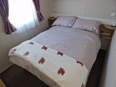 A bed with a blanket in a bedroom at Seafront Caravan - Golden Sands - 6 Berth by Your Away Stays in Kinmel Bay