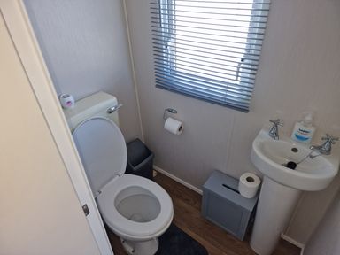 A bathroom with a toilet and sink in Seafront Caravan - Golden Sands - 6 Berth by Your Away Stays Kinmel Bay