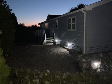 A house with steps and lights at Holly Blue - Cosy wooden lodge, Kippford near Kippford Holiday Park