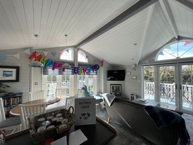 A living room with a birthday decoration at Butterfly Lodges in Kippford Holiday Park near Dalbeattie