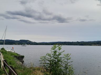 A view of a lake with a boat and greenery at Ye Old'e Man - Sleeps 6 &amp; Pet Friendly near Flookburgh