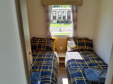A bedroom with twin beds and towels at Ye Old'e Man - Sleeps 6 & Pet Friendly near Flookburgh
