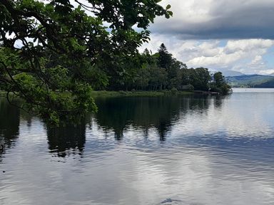 A lake with trees and clouds near Flookburgh