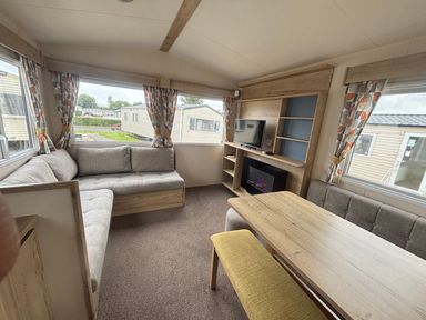 A living room with a sofa and table at Caravan Sleeps 5 - Decking, Parking, Pet Friendly in Blackpool