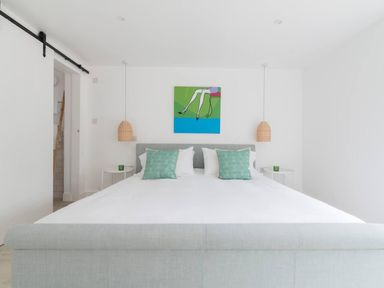 A bedroom with a bed and wall art at Simple Coastal Luxury near Southwold