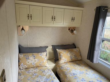 A bedroom with two beds and cabinets at Chalet Sleeps 4 Near Cymyran Beach in Caergeiliog