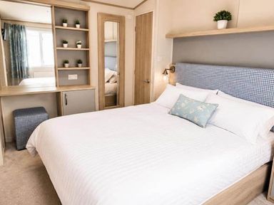 A bedroom with a bed and storage unit at Tattershall Lakes - Hot Tub - Sleeps 6 - Pets Tattershall