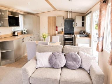 A kitchen/living area with a sofa and dining table at Tattershall Lakes - Hot Tub - Sleeps 6 - Pets Tattershall