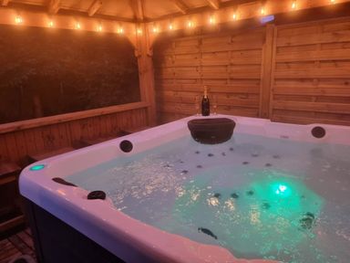 A hot tub with champagne and glasses at Cabin Sleeps 4 with Hot Tub and Parking Near Wilberfoss