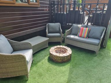 An outdoor seating area with sofas and a fire pit at Cabin Sleeps 4 with Hot Tub and Parking near Wilberfoss