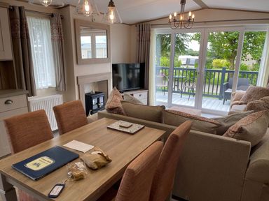 A living room with a dining table and a sofa with a view of the deck at the property in location