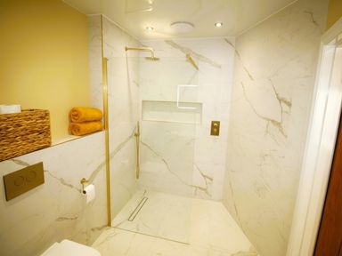 A bathroom with a shower and towels at Newly Refurbished Cottage, sleeping 4 and Central Berwick-Upon-Tweed