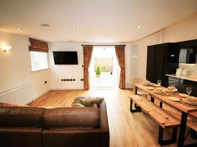 A living room with a television and dining table at Newly Refurbished Cottage, sleeping 4 and Central Berwick-Upon-Tweed